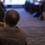 People sitting in rows of chairs at a conference