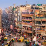 A busy and crowdy market with buildings and people moving around