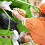 Sanitation worker putting trash into the trash truck