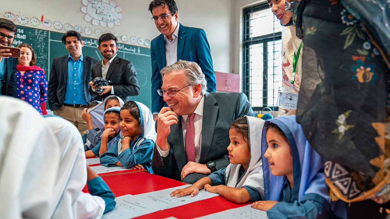 Adults and children in a classroom, adults smiling